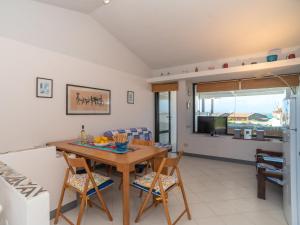 eine Küche und ein Wohnzimmer mit einem Tisch und Stühlen in der Unterkunft Holiday Home Sa Casitta by Interhome in Stintino