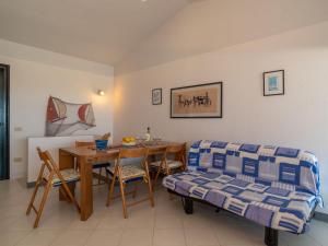 een woonkamer met een tafel en een bank bij Holiday Home Sa Casitta by Interhome in Stintino