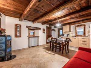 una cucina e una sala da pranzo con soffitti in legno e divano rosso di Apartment Les Cors-1 by Interhome a Fenis