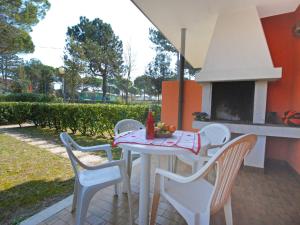 patio con mesa, sillas y fogones en Apartment Villaggio Nautilus by Interhome, en Bibione