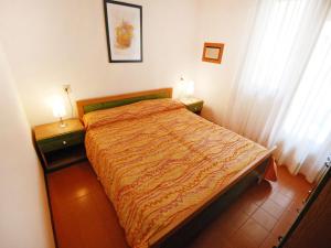 1 dormitorio con 1 cama y 2 mesitas de noche con lámparas en Apartment Villaggio Nautilus by Interhome, en Bibione