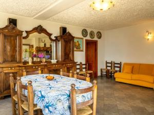 une salle à manger avec une table et un canapé jaune dans l'établissement Apartment Malpensata by Interhome, à Porto Valtravaglia