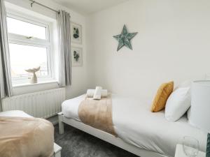 een slaapkamer met een bed en een zeester aan de muur bij Little Tern in Weymouth