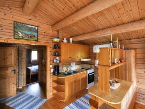 a kitchen in a log cabin with a sink and a stove at Chalet Fjordblick I - FJS311 by Interhome in Olden