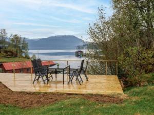 a wooden deck with two chairs and a table at Holiday Home Nystølen - FJH657 by Interhome in Håvik