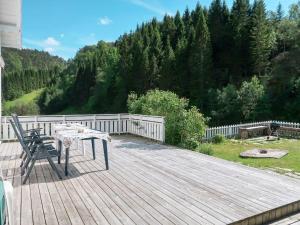 a wooden deck with a table and a chair on it at Holiday Home Nystølen - FJH657 by Interhome in Håvik