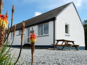 a house with a picnic bench in front of it at Holiday Home Alan's House by Interhome in Staffin