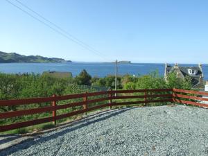 a fence with the ocean in the background at Holiday Home Alan's House by Interhome in Staffin