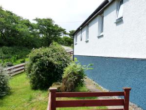 a wooden bench sitting next to a building at Holiday Home Alan's House by Interhome in Staffin +24 photos