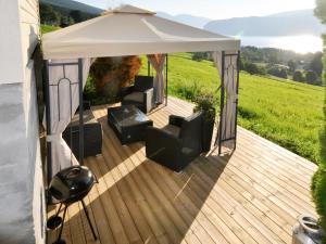 a gazebo with two chairs and a table at Chalet Nystova - FJS250 by Interhome in Innvik