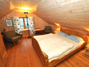 ein Schlafzimmer mit einem Bett und einem Stuhl in einem Zimmer in der Unterkunft Chalet Nystova - FJS250 by Interhome in Innvik