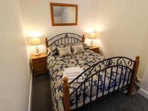 Chelmortonにある1 Primitive Croftのベッドルーム1室(ベッド1台、ランプ2つ、鏡付)