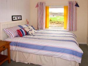 a bedroom with a large bed with a window at Waterloo Cottage Annexe in Ruswarp