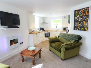 uma sala de estar com um sofá, uma televisão e uma mesa em 2 Riverside em Barnard Castle