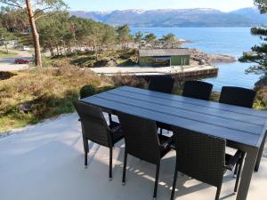 a blue table and chairs on a patio with a view of the water at Holiday Home Blåsenberg - FJS126 by Interhome in Leirvik