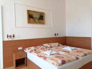 a bedroom with a bed and a picture on the wall at Hotel Morava in Znojmo