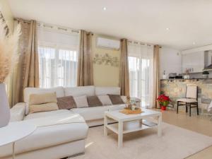a living room with a white couch and a table at Holiday Home Emballia by Interhome in Caulés +25 photos