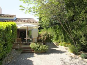 ヴィルヌーヴ・レ・ザヴィニョンにあるHoliday Home L'Oasis provencale - AVI120 by Interhomeの庭園(テーブル、傘付)
