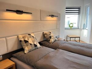 1 Schlafzimmer mit 2 Betten und einem Kopfteil in der Unterkunft BASSWOOD ROOMS in Bremen
