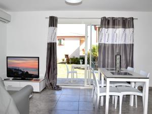 サンタ・ルシア・ディ・モリアニにあるApartment Marea Resort-1 by Interhomeのダイニングルーム(テーブル、テレビ付)