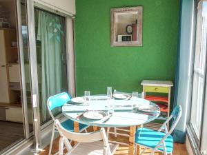 サン・シプリアン・プラージュにあるApartment Marinas du Ponant by Interhomeの緑の壁の部屋(テーブル、椅子付)