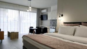 a bedroom with a bed and a table and a kitchen at Psammites in Kalabaka
