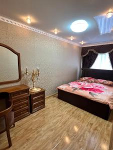オルスクにあるАпартаменты "ЦЕНТР-ОРСК"のベッドルーム1室(ベッド1台、ドレッサー、鏡付)