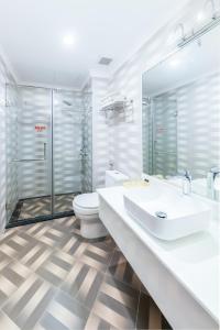 a bathroom with a toilet and a sink and a shower at Golden Rose Hotel by THG in Da Nang