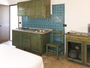オロゼーイにあるApartment Gli Ontani mono by Interhomeのキッチン(緑のキャビネット、シンク、椅子付)