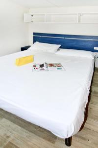 een bed in een kamer met een tijdschrift erop bij Holiday Home Camping Thurium by Interhome in Marina di Schiavonea +17 foto's