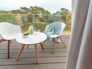 een witte tafel en stoelen op een balkon met een raam bij Apartment Mariandl am Meer-1 by Interhome in Binz
