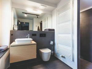 a bathroom with a sink and a toilet and a mirror at Apartment Mariandl am Meer-1 by Interhome in Binz