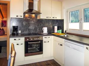 een keuken met witte kasten en een fornuis met oven bij Apartment Jacqueline - HBN180 by Interhome in Längenfeld