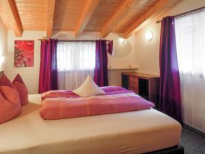 een slaapkamer met een groot bed met paarse gordijnen bij Apartment Jacqueline - HBN180 by Interhome in Längenfeld