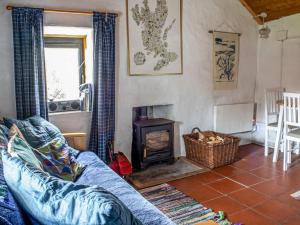 a living room with a couch and a wood stove at Holiday Home Tigh Phoil by Interhome in Elgol