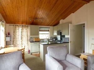 a kitchen with two chairs and a living room at South Lodge in Staveley +12 photos