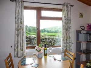 een eetkamer met een tafel en een raam bij South Lodge in Staveley