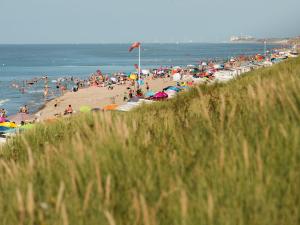 een druk strand met veel mensen in het water bij Apartment Residentie Astrid-8 by Interhome in Bredene