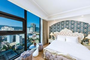 a bedroom with a white bed and a large window at Golden Rose Hotel by THG in Da Nang