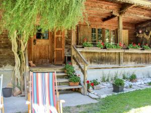 a porch of a log cabin with a staircase and flowers at Holiday Home Siglaste by Interhome in Ginzling