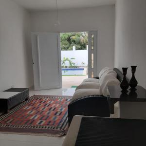 a room with four beds and a door to a pool at Casa Vitória em barra de jacuipe in Campos +32 photos