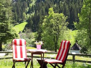 two chairs and a table with a vase on it at Holiday Home Siglaste by Interhome in Ginzling