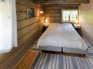 a bedroom with a bed in a wooden wall at Chalet Eiketun - FJS309 by Interhome in Olden