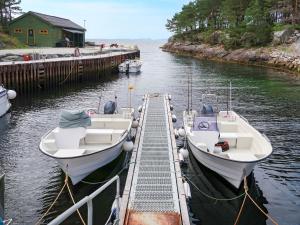 dos barcos están atracados en un muelle en el agua en Holiday Home Nesholmen - FJS127 by Interhome, en Leirvik