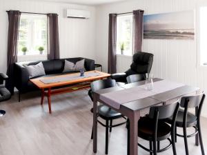 sala de estar con mesa y sofá en Holiday Home Nesholmen - FJS127 by Interhome, en Leirvik