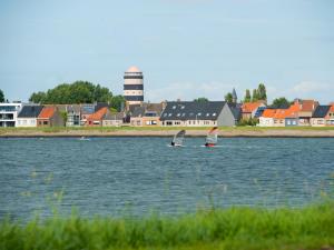 two sailboats in the water in front of a town at Studio Studio met garage by Interhome in Bredene
