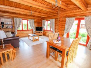 a living room with a table and chairs in a log cabin at Cedar Lodge in Oakham