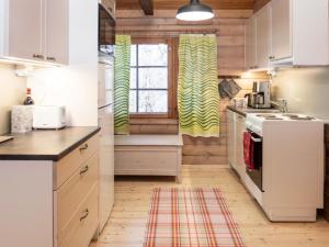 una cocina con armarios blancos y una ventana en Holiday Home Vaaran tupa by Interhome en Ruka