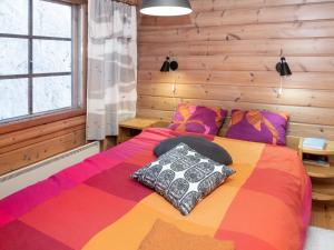 1 dormitorio con 1 cama con una manta colorida en Holiday Home Vaaran tupa by Interhome en Ruka