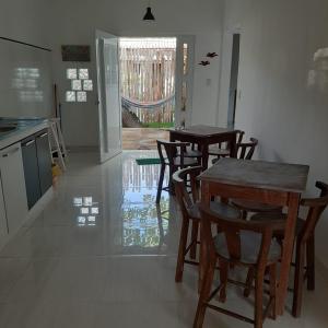 une salle à manger avec des tables et des chaises ainsi qu'une cuisine dans l'établissement Casa Vitória em barra de jacuipe, à Campos